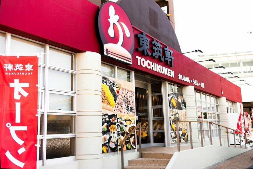 東筑軒のロードサイドモデル1号店。折尾駅から徒歩2分の場所にある。本社1階を全面リニューアルして店舗に。なお、東筑軒は駅構内に6店、海老津駅前に1店と7店舗うどん店を展開しているが、本格的に“駅の外”へと出るための出店は今回が初めての試みだ（写真：筆者撮影）