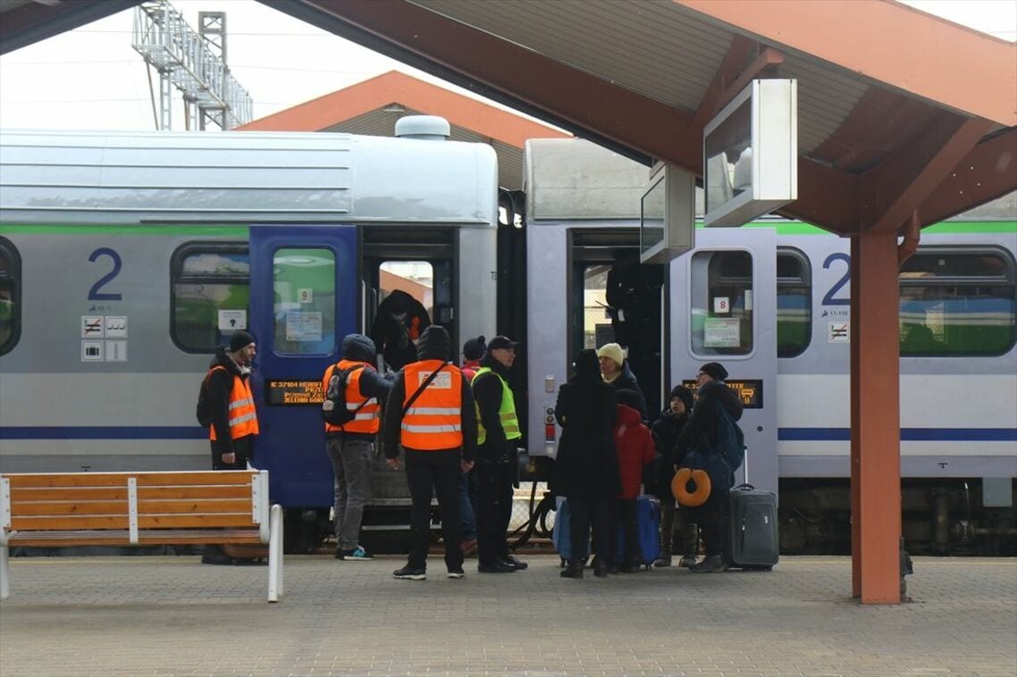 ポーランドの列車と避難民を案内するスタッフ