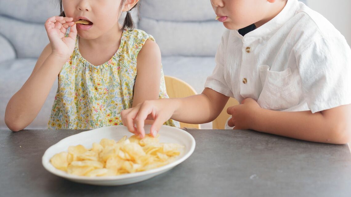 スナック菓子を食べる子ども