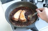 スプーンでブリにたれをかける