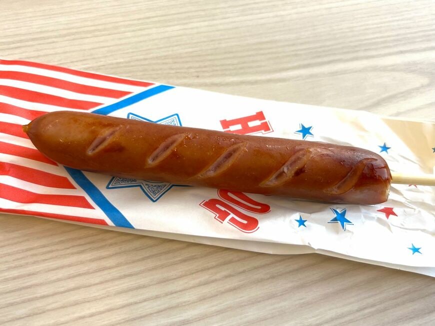 フランクフルト100円。塩味があり、ケチャップやマスタードをかけずにそのままおいしく食べられる。子ども連れでも服を汚すリスクを減らせる（筆者撮影）