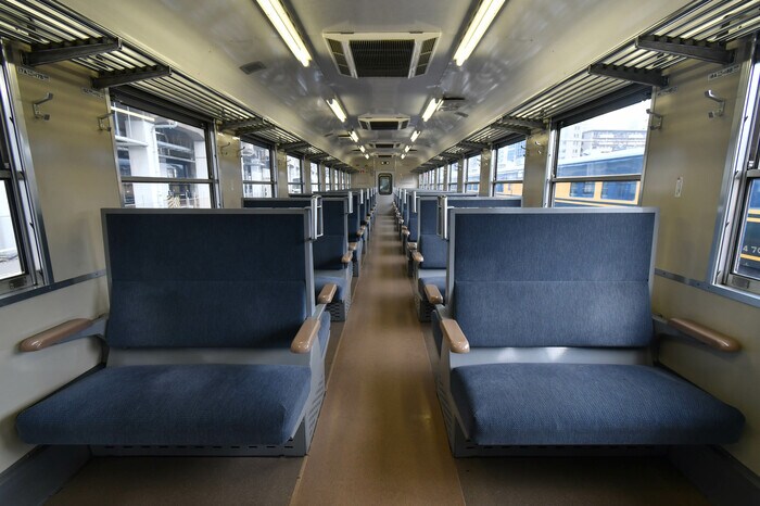 ボックスシートが整然と並ぶ車内。天井にはクーラーの