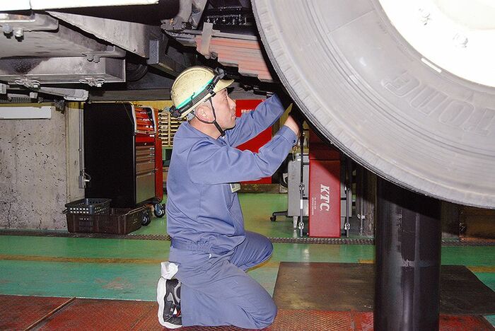 トロリーバスの下にもぐって整備にあたる早川さん