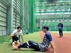 秋本コーチ（左）は古川雄大外野手にストレッチの方法も指導