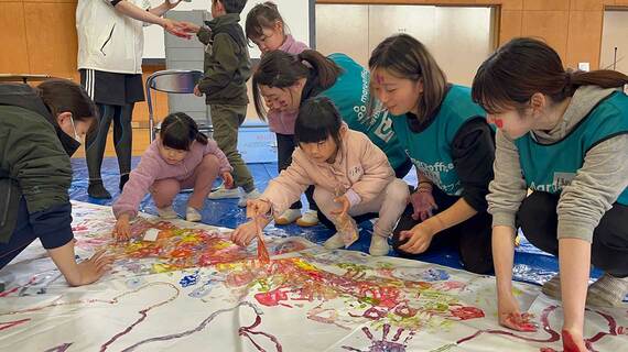 子どもとスタッフが一緒に絵の具でお絵かき
