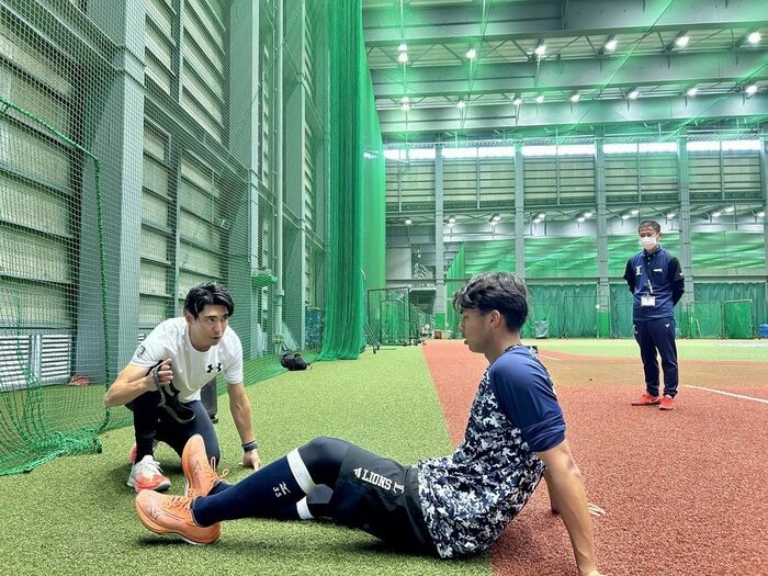 秋本コーチ（左）は古川雄大外野手にストレッチの方法も指導
