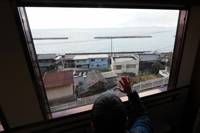 画面中央の電柱付近に旗を振る人が。アテンダントが