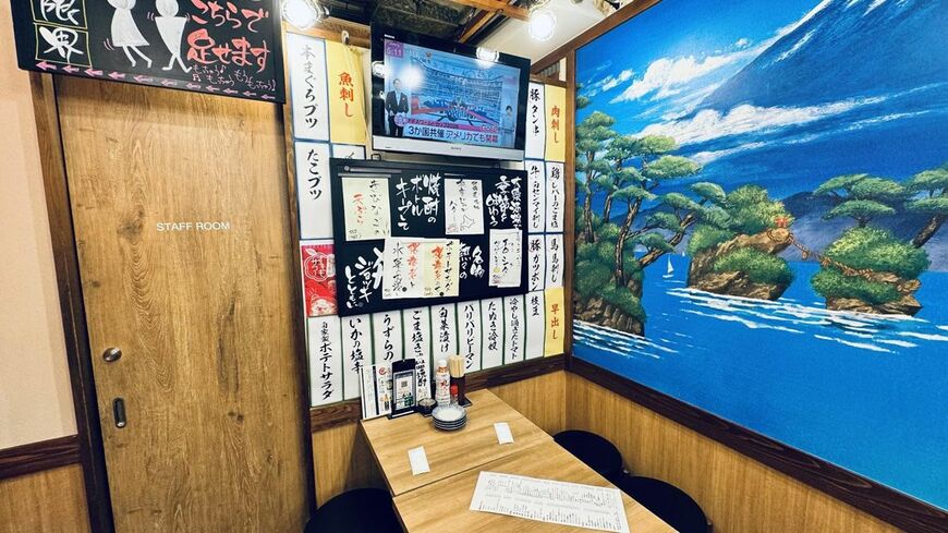 壁面には手書き風のメニュー札が並び、テレビも設置されている。清潔感はありつつ、大衆酒場らしいにぎわいを感じる店内（写真：筆者撮影）