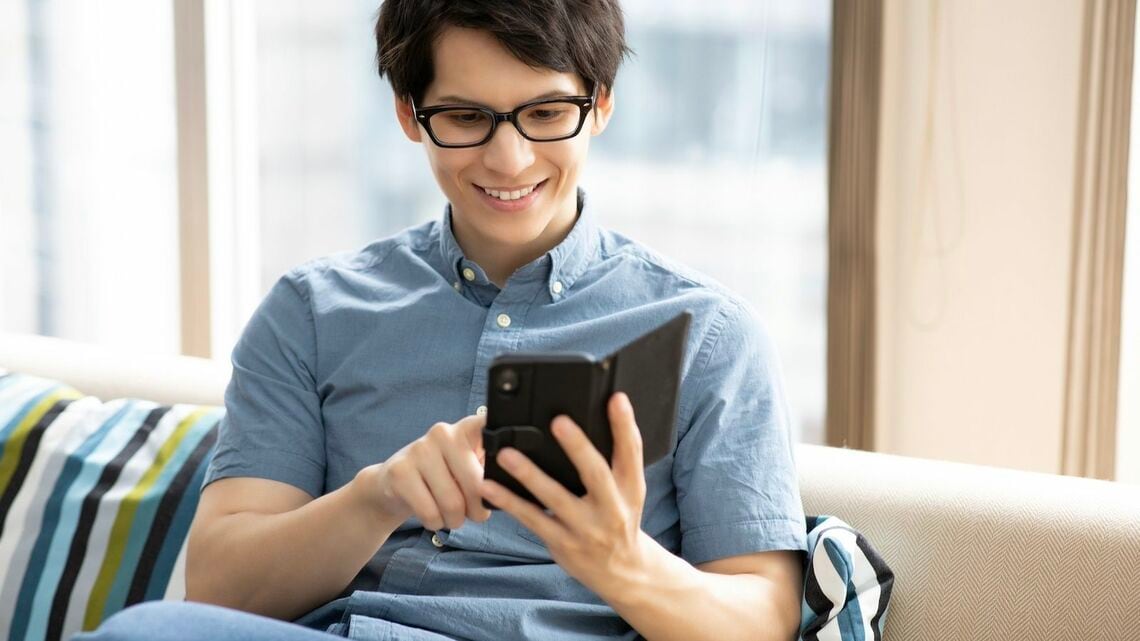 ソファーでスマホを見る男性