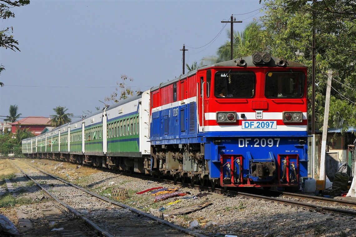ミャンマー国鉄が近年増備した中国中車大連製の電気式ディーゼル機関車。22両が導入されうち10両がミャンマーでのノックダウン生産。後ろに連なるのは中国中車四方製の新型客車。優等列車の主役になっており、軌道改良後は時速100km走行も可能になる（写真：増田理人）