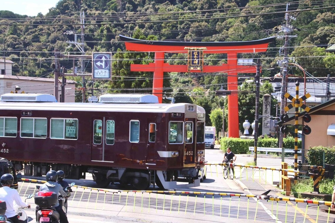 松尾大社の大鳥居を横目に走る6300系。嵐山線転用時にドア窓が拡大されている（撮影：南正時）