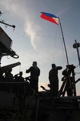 朝、国旗を掲揚するシエラマドレ号の海兵隊員ら（2014年8月、写真・柴田直治）
