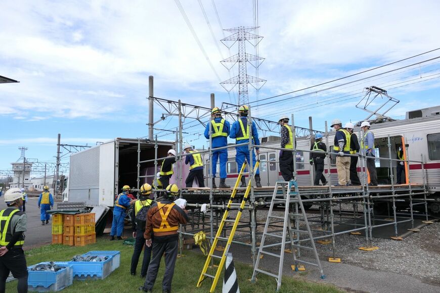 トラックから運び出したホームドアの筐体（きょうたい）を10000型に積み込む（記者撮影）