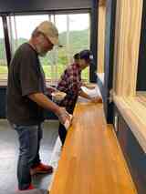 建築事務所からコツを教わり、慎重に蜜蝋ワックスを塗る寺川さん（左）と斎藤さん（右）（写真：Anique）