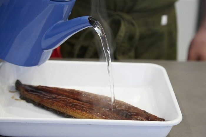 バットに入れたうなぎに熱湯をジャバジャバ