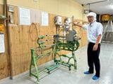 掛巻機（かけばき）の説明をする谷口さん。オフシーズンは工場と機械のメンテナンス期間、ちょうど工場清掃後で床がピカピカだった（筆者撮影）