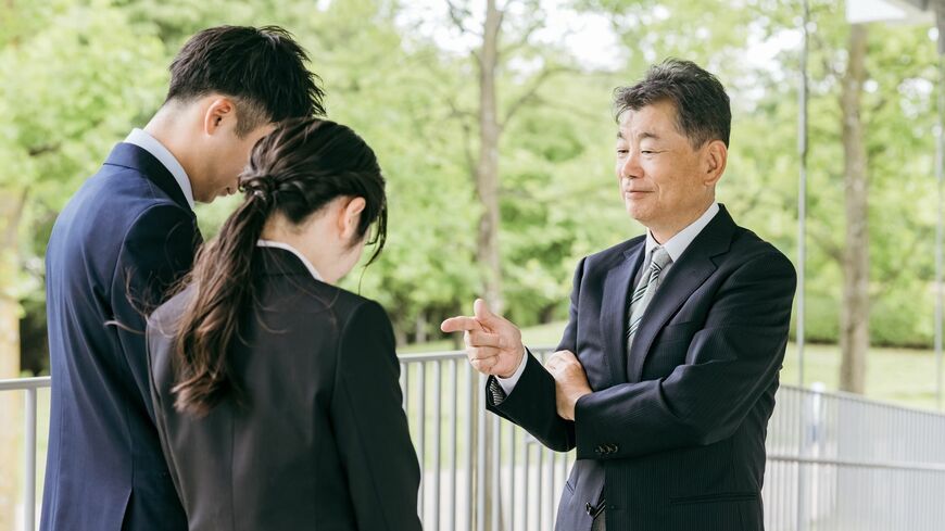 説教・叱咤激励される若いビジネスマン男女