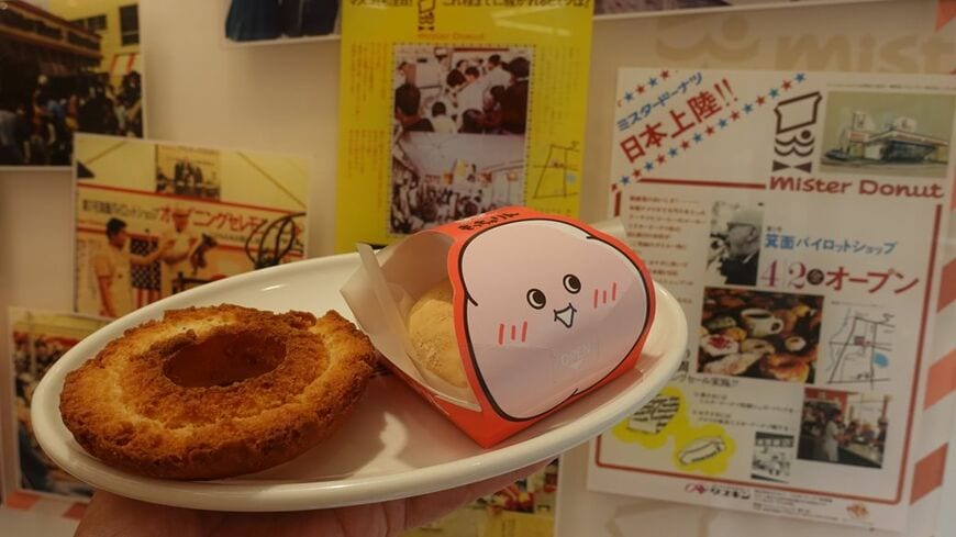 ミスタードーナツの開業当時のチラシと「もっちゅりん」。箕面ショップにて（筆者撮影）