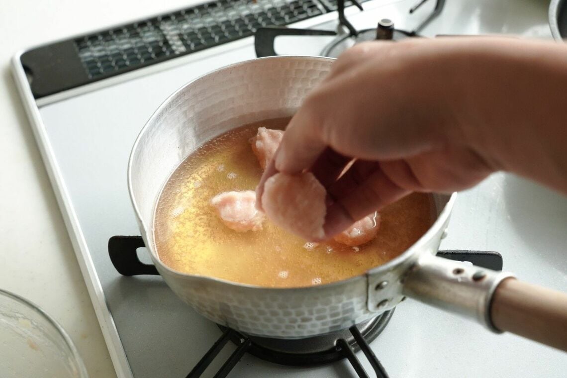 だしに鶏団子を投入