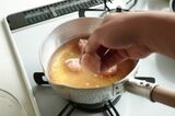 だしに鶏団子を投入