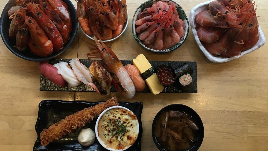 「俺の魚を食ってみろ!!」では3850円でエビ、寿司が食べ放題。赤エビ、甘エビのそれぞれ刺身と、焼き赤エビ、揚げ甘エビの4種類を提供する。カレーマヨネーズ、エビマヨネーズなどの味変も楽しめる。写真下のエビフライ、エビグラタンも同店自慢のメニュー（筆者撮影）