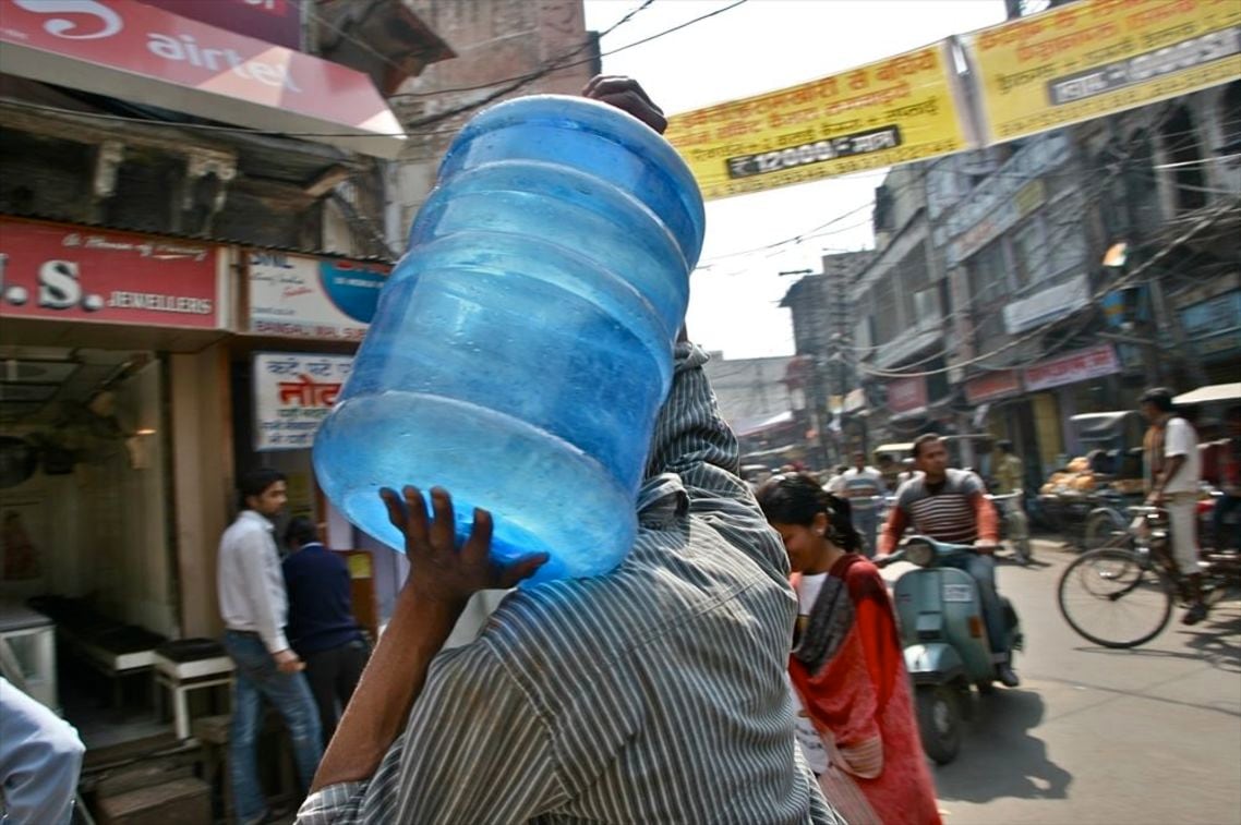 アグラの街角で運ばれる水のボトル。飲料水ビジネスは活況だ