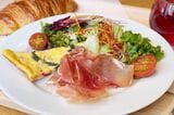 プリンチブレックファストフリッタータ。見た目も美しい朝食プレートの主役は、薄くカットされた半透明でツヤのある大ぶりの生ハム（筆者撮影）