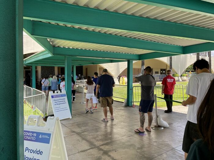 コロナウイルスの予防接種のために並ぶ人々