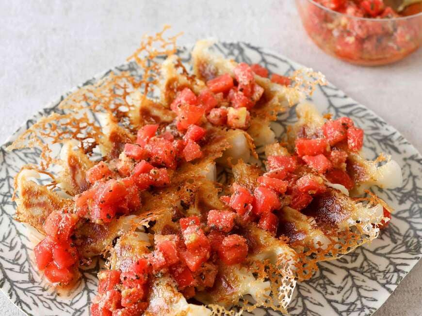 角切りにしたトマトに粉チーズや酢、オリーブオイル、乾燥バジル、塩、コショウを混ぜ、焼いた餃子にかける（『いますぐ食べたい！冷凍食品の本』より）