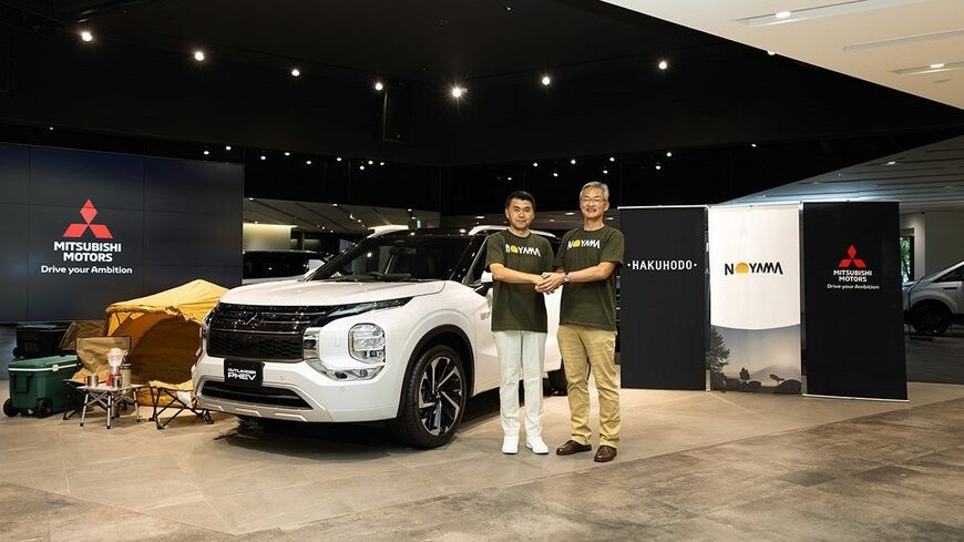 博報堂 取締役常務執行役員・名倉健司氏（左）と三菱自動車工業 代表執行役副社長・中村達夫氏（右）が手を取りあった（写真：三菱自動車工業）