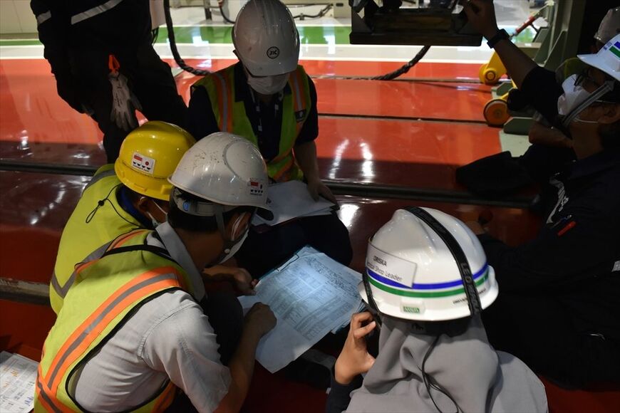 床下機器箱の搭載品をチェックシートで確認中の電気班（筆者撮影）