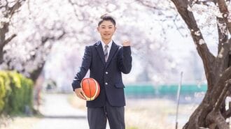 桜の下でバスケットボールを持つ男子学生