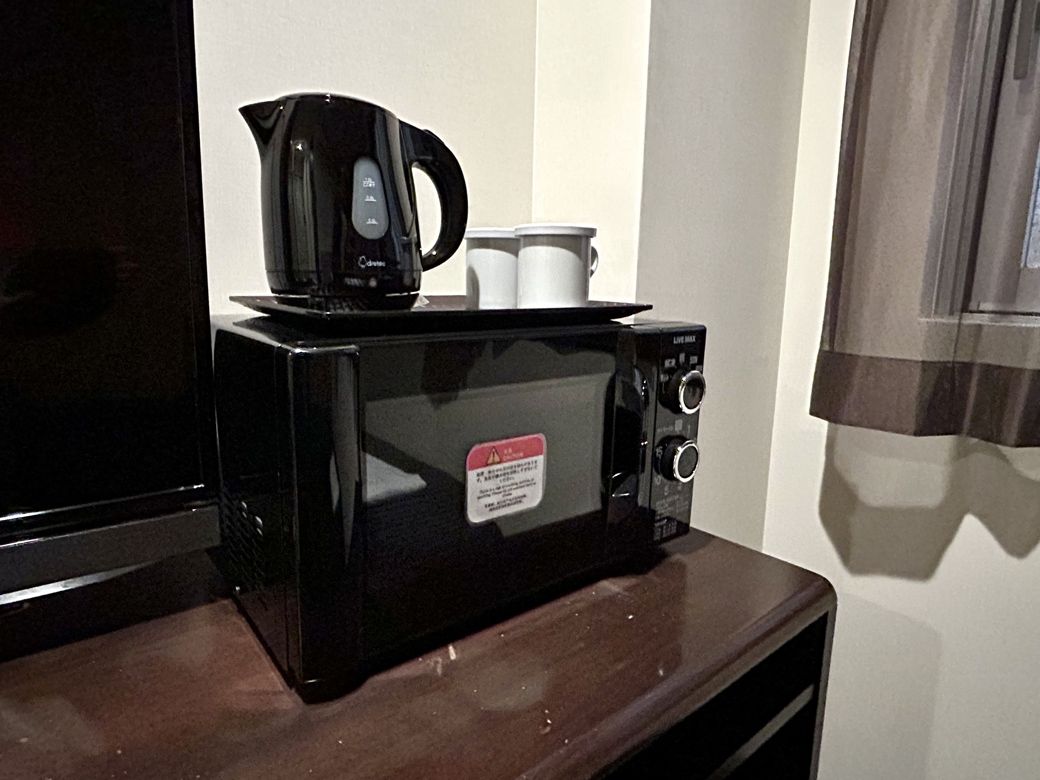 部屋に1台、ターンテーブル式の電子レンジ完備。正直これには驚いた。電子ケトルとマグカップ2個も。コーヒーと紅茶、2種類を同時に飲める。うれしい（写真：筆者撮影）