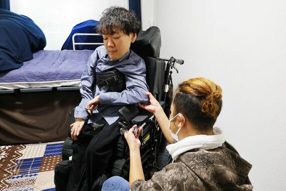ヘルパーの介助を受ける青木さん