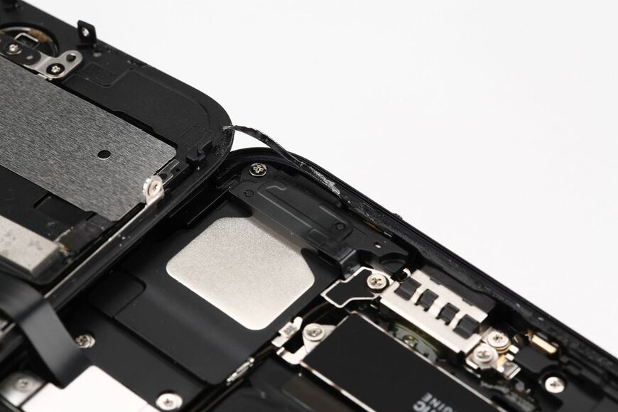 初めて「耐水」をうたったiPhone 7を分解したところ。粘着性のあるパッキンが見える。一度ボディを開けると、パッキンは破れて効果がなくなってしまう（写真：筆者撮影）