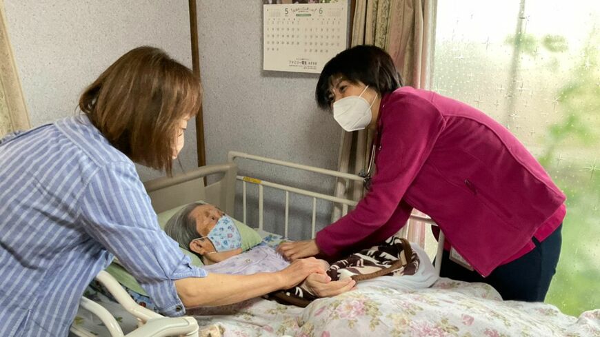 患者家族と会話をする筆者。在宅だと話せるのに、病院では……。今回は医師とのコミュニケーションについて紹介します（写真：筆者提供）