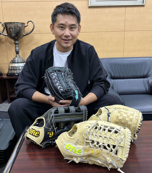 松坂恭平さんは自社で手がけたグラブ「ONE OF THE ANSWER」を手にした。机上の左が今季ソフトバンク柳田が使用、手前が巨人松田が使用したモデル（撮影：久我悟）