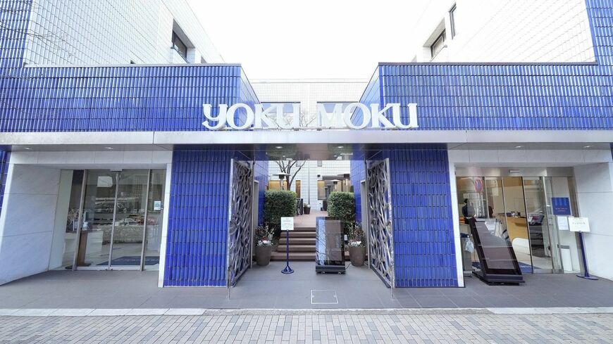 青山のブランド店が並ぶ界隈にひときわ瀟洒に佇むヨックモック青山本店及び喫茶室ブルー・ブリック・ラウンジ。季節のスイーツのほかランチが人気で、順番待ちの列ができるほどだ。またコロナ前にはインバウンドも多く、シガールがヒットした中東から訪れた民族衣装姿の男性客もときどき見られたという（撮影：梅谷秀司）この記事の画像を見る(◯枚)