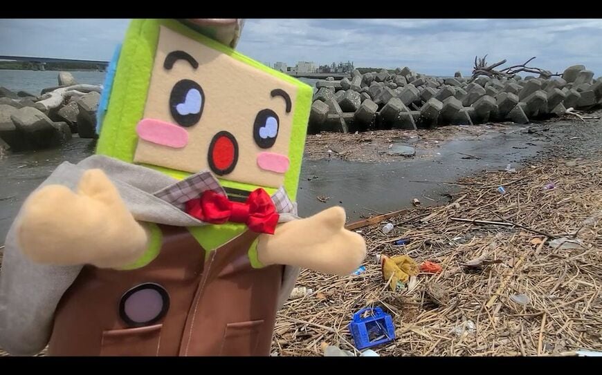 デジタル紙芝居の動画に登場する探偵に扮したパッカ君（画像：座間市清掃職員奥脇さんの作成動画より）