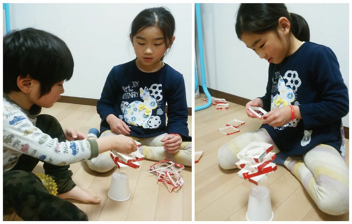 ゆらゆらタワーで遊ぶ園児と小学生。いくつのせられるかな？（筆者提供）