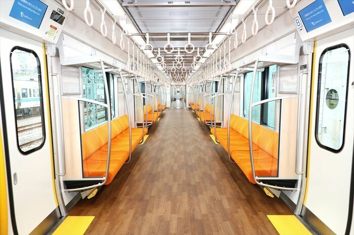 白い壁にオレンジ色のシートが目立つ車内