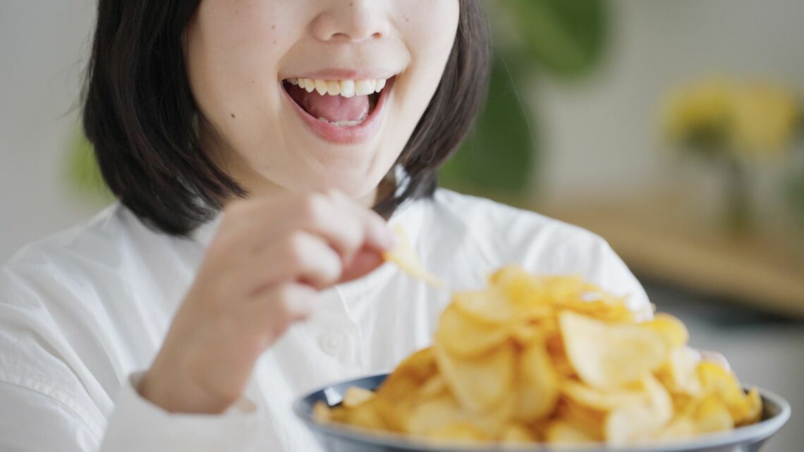 ポテトチップスを食べる女性