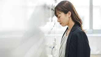 プレッシャーを感じて壁に頭をつける女性