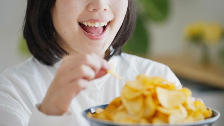 ポテトチップスを食べる女性