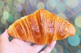 大きめサイズのクロワッサンは、表面はサクッと軽やかで、中はバターたっぷりでしっとりとした味わい（筆者撮影）