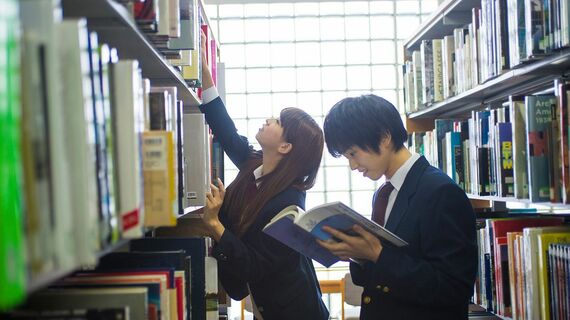図書館で調べ物をする高校生