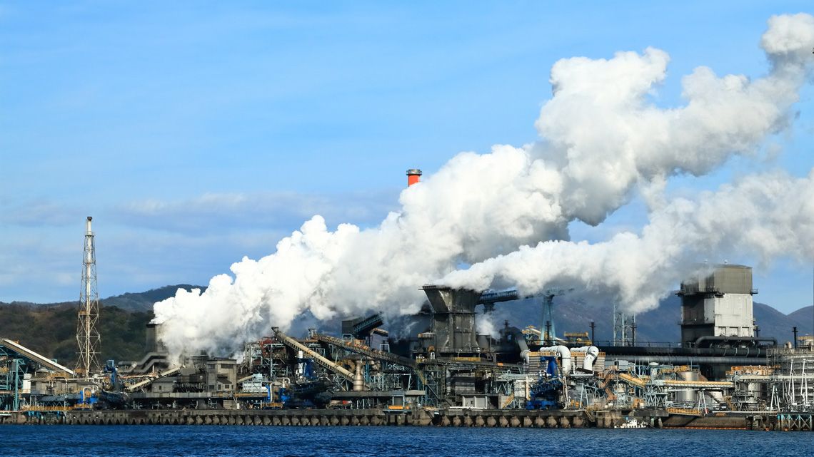 白い煙をあげる工場の遠景