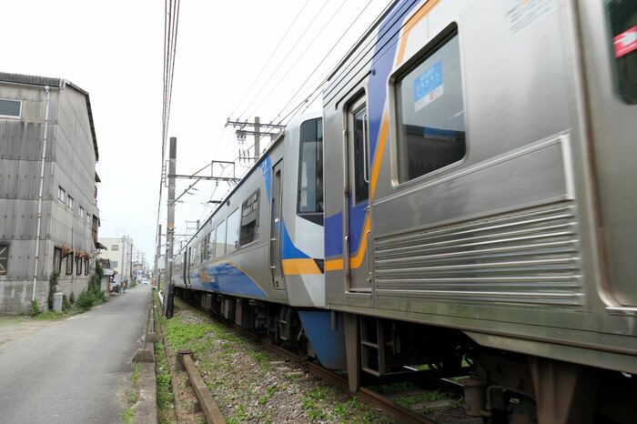 後ろが12000系。青とオレンジの帯が