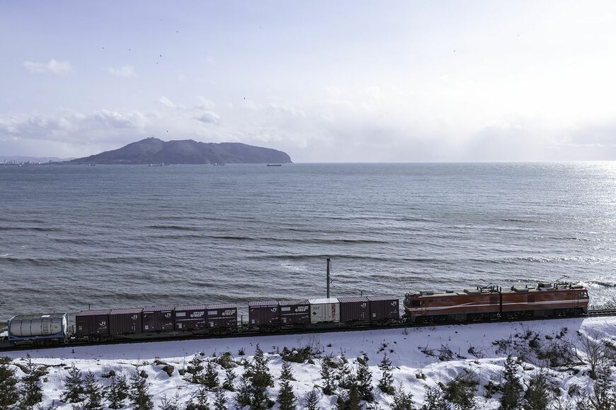 函館山を望みながら道南いさりび鉄道線を走り青函トンネルに向かう上り貨物列車。青函トンネルは津軽海峡の荒波も関係ないルート（上磯～茂辺地）（写真：山井美希）
