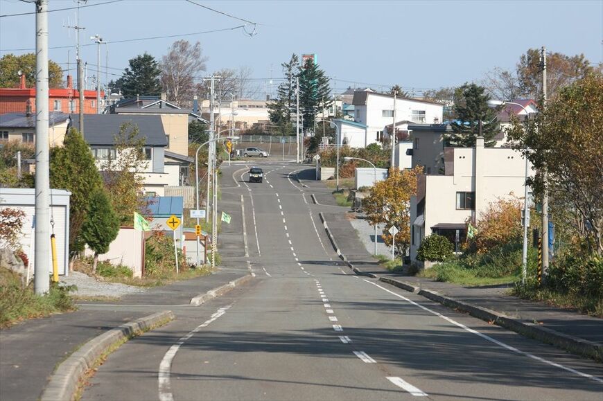 北見枝幸―南枝幸（信）間：枝幸町の中心市街地を貫いていた美幸線の路盤は区画整理で消滅した部分や、写真のように路盤を撤去して道路に造り直した部分がある（筆者撮影）
